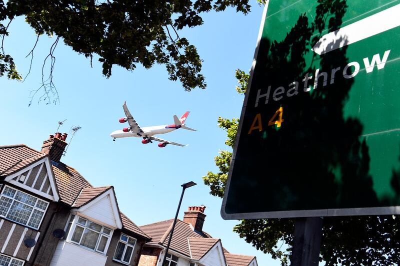 epa06838862 A Virgin plane passes houses as it comes into land at Heathrow Airport in Hounslow, Britain, 25 June 2018. Britain's Parliament votes on plans to expand the airport with a third runway on 25 June 2018.  EPA/NEIL HALL
