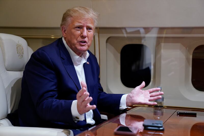 Donald Trump speaks with reporters while in flight on March 25. AP