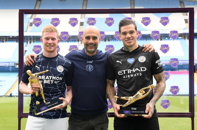 MANCHESTER, ENGLAND - JULY 26:  Ederson of Manchester City  holds the Golden Glove Award and Kevin De Bruyne of Manchester City holds the Playmaker Award alongside Pep Guardiola, Manager of Manchester City after the Premier League match between Manchester City and Norwich City at Etihad Stadium on July 26, 2020 in Manchester, England.Football Stadiums around Europe remain empty due to the Coronavirus Pandemic as Government social distancing laws prohibit fans inside venues resulting in all fixtures being played behind closed doors. (Photo by Shaun Botterill/Getty Images)