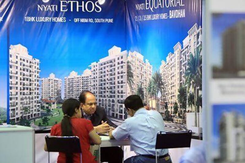 Indian expatriates meet with a salesman in December at the Nyati Ethos stall at the Indian Property Show at the Dubai World Trade Centre. Ravindranath K / The National