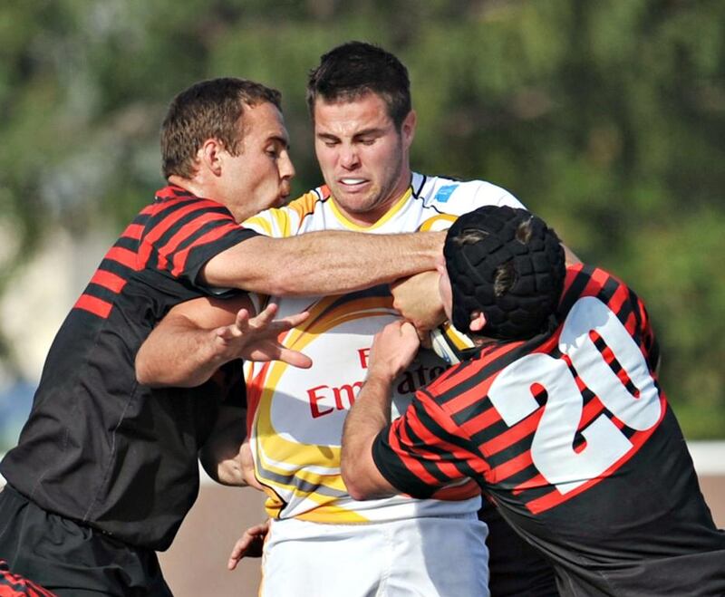 Abu Dhabi Saracens, in red, surround a Dubai Hurricane during their 21-18 win at The Sevens in Dubai City, Dubai on February 28, 2014. Jeff Topping for The National