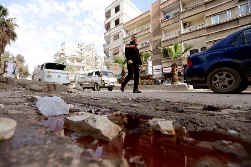 A Syrian man walks past a pool of blood following shelling in the Jaramana southeastern district of Damascus.  Louai Beshara / AFP Photo