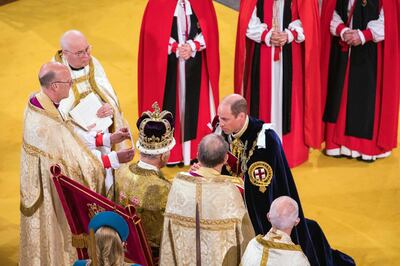 Prince William  kneels in front of King Charles. AP