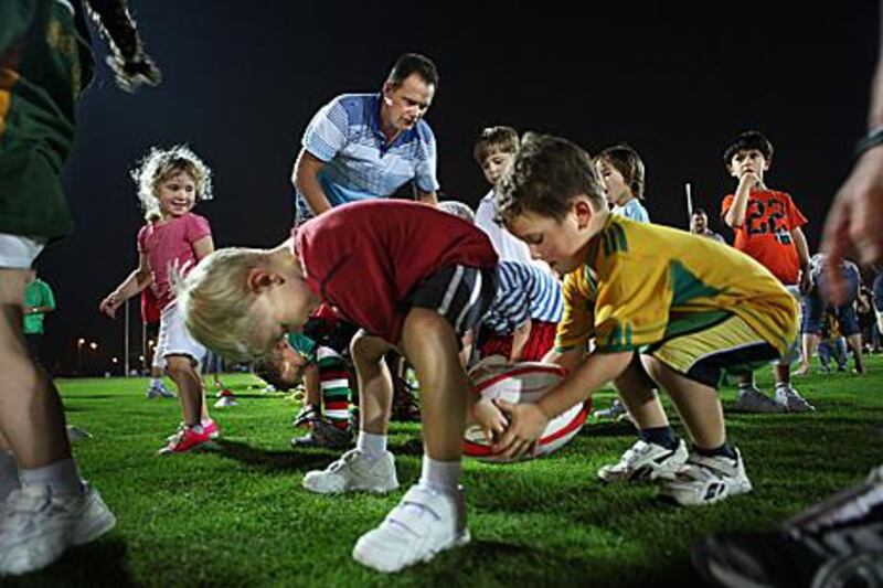 With a little help from adults, children perform skills exercises at the start of the new rugby union season which kicked off in September at Zayed Sports City.