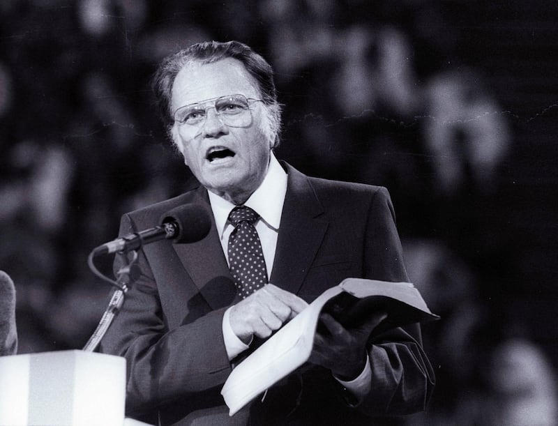 FILE PHOTO: Evangelist Billy Graham, preaches the Gospel to thousands of believers during the meeting at Bercy's Stadium in Paris as part of a worldwide crusade, September 20, 1986.   REUTERS/Stringer/File Photo