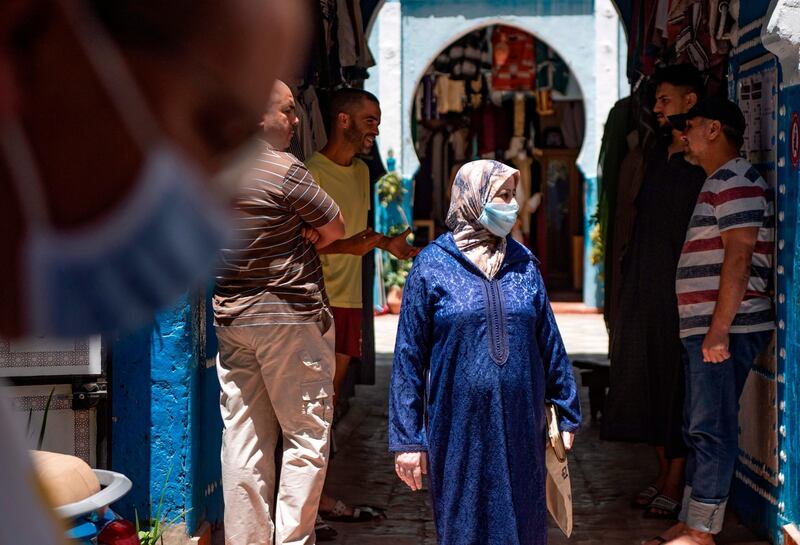 A Moroccan woman, wearing protective face mask, walks on a street in Tangiers' Old City, after the re-introduction of restriction measures to contain the coronavirus.  AFP