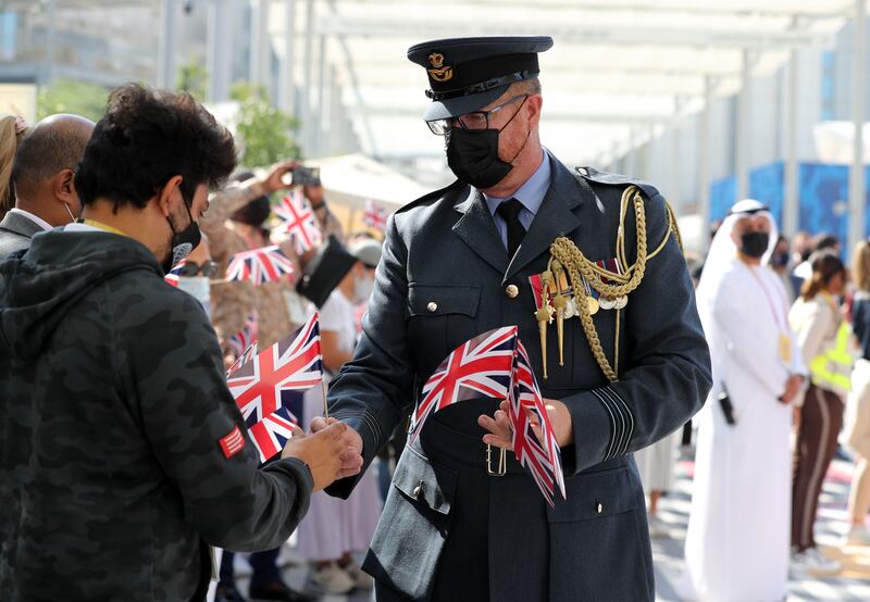 Flags are handed out before a parade to mark UK 'national day'.