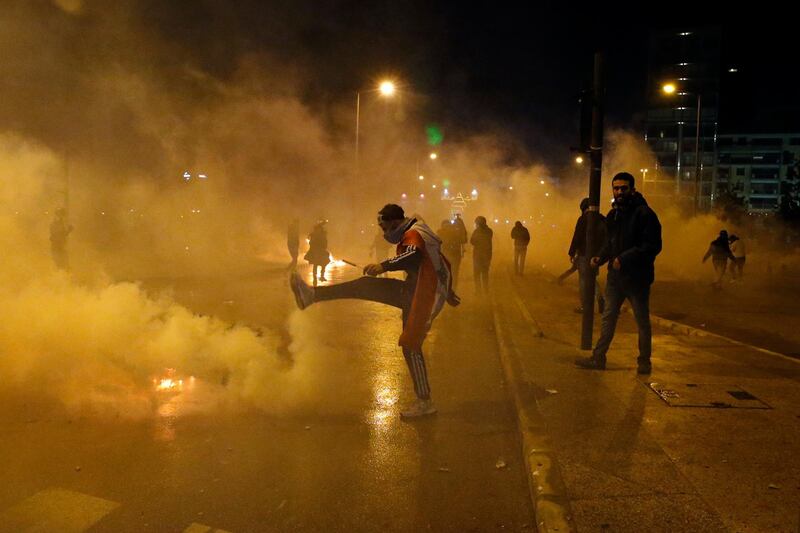 An anti-government demonstrator kicks a tear gas canister that was fired by Lebanese riot police in Beirut. AP Photo