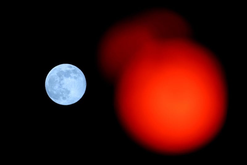 A red traffic light with the pink supermoon in the background, in High Wycombe, England. Getty Images