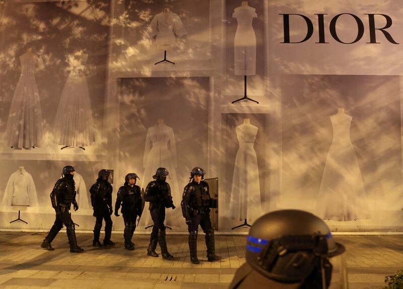 Police officers stand guard in front of the Dior building on Champs Elysees avenue in Paris. Reuters