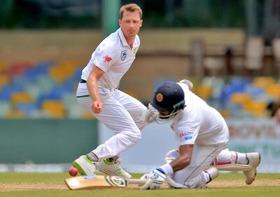 South Africa's Dale Steyn, left, watches Sri Lanka's Dimuth Karunaratne, right, dive to make it successfully to the crease during the first day's play of their second test cricket match in Colombo, Sri Lanka, Friday, July 20, 2018. (AP Photo/Eranga Jayawardena)