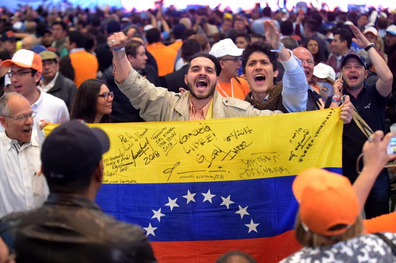 Supporters of the presidential candidate for Colombia's Democratic Center Party, Ivan Duque, react in Bogota as the results from the presidential runoff election in Colombia come in, on June 17, 2018. Colombians choose a new president Sunday in a landmark election, the first since a peace agreement with FARC rebels which conservative frontrunner Ivan Duque wants to overhaul. / AFP / Raul Arboleda                       
