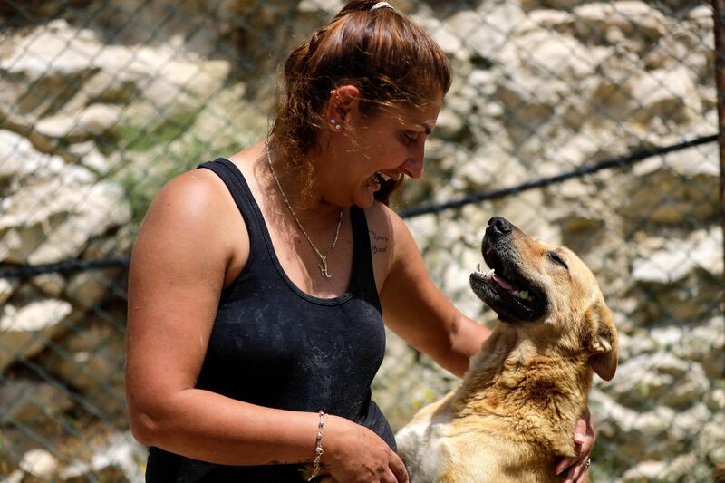 Volunteer Ghada Al Khateeb plays with a rescued dog at the shelter. AFP