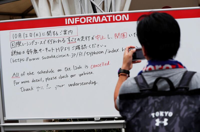 A spectator takes photos of an information board announcing the cancellation of all practice and qualifying sessions scheduled for Saturday due to the approach of Typhoon Hagibis, at Formula One Japanese Grand Prix at Suzuka Circuit in Suzuka, central Japan October 11, 2019.   REUTERS/Issei Kato