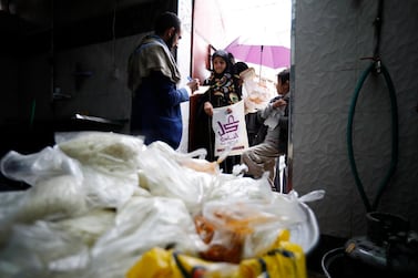 A volunteer provides free food rations to Yemeni children at a charity group in Sanaa, Yemen. EPA  