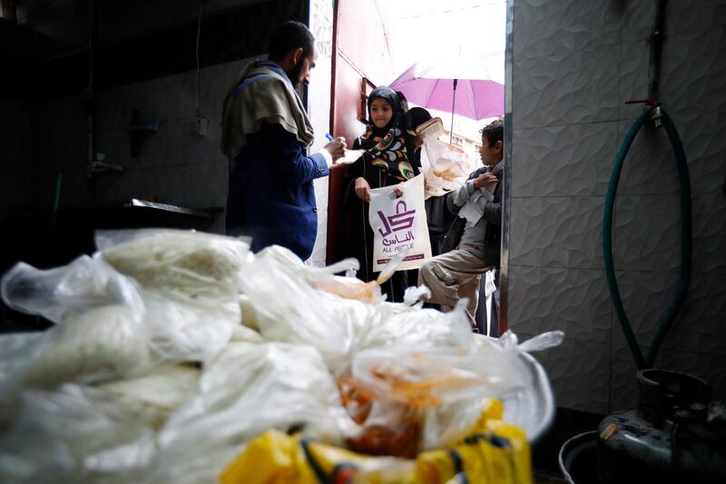 epa08401650 A volunteer provides free food rations to Yemeni children at a charity group in Sana'a, Yemen, 04 May 2020. According to reports, nearly 80 percent of Yemen's 27 million-population rely on humanitarian aid while half of the population faces famine due to a prolonged conflict that triggered what is considered to be the world's worst humanitarian crisis.  EPA/YAHYA ARHAB