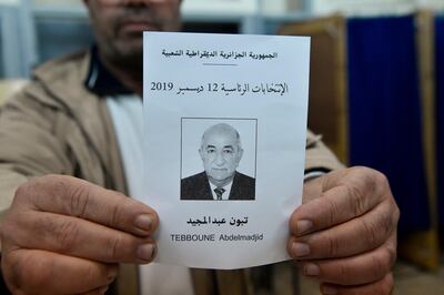 An election official displays a ballot paper of Algeria's presidential candidate Abdelmadjid Tebboune during the counting process in the capital Algiers on December 12, 2019. Algeria held a tense presidential election meant to bring stability after a year of turmoil, but voting was marred as protesters stormed polling stations and staged mass rallies in the capital. / AFP / RYAD KRAMDI                        
