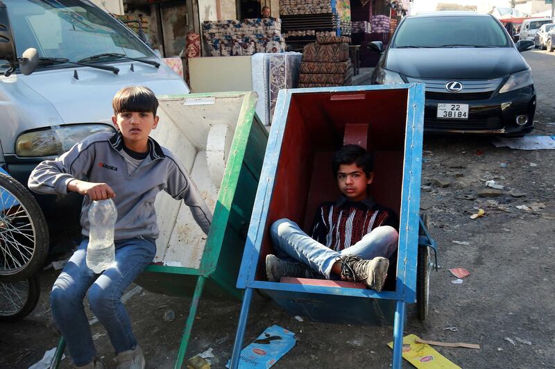 Children take a break from working in Amman's Wahdat district. Residents have reported a surge in the number of children working there. AFP