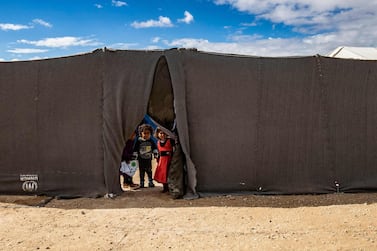 Children peek through the opening of a tent at the Kurdish-run Al Hol camp which holds suspected relatives of ISIS fighters, in the north-eastern Syrian Hassakeh governorate AFP