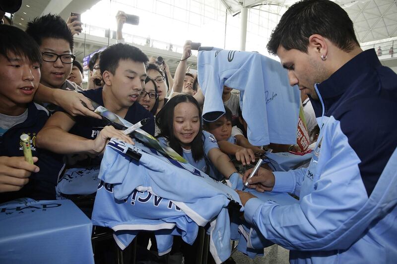 HONG KONG - JULY 22:  Manchester City player Sergio Aguero signs autographs memorabilia for Manchester City fans at Hong Kong Airport shortly after the team arrives to compete in the Barclays Asia Trophy, on July 22, 2013 in Hong Kong. (Photo by Jessica Hromas/Getty Images)
