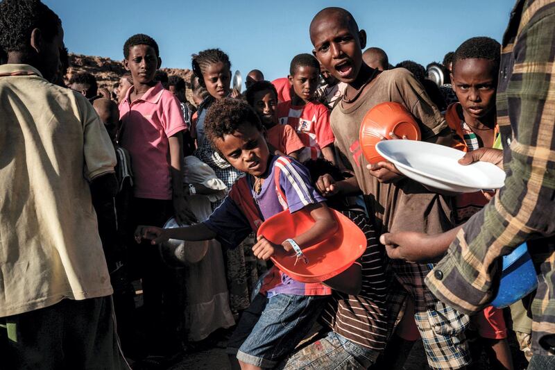 Ethiopian refugee children who fled the Ethiopia's Tigray conflict have a little fight as they wait for a food distribution by Muslim Aid at the Um Raquba refugee camp in Sudan's eastern Gedaref state on December 12, 2020. (Photo by Yasuyoshi CHIBA / AFP)