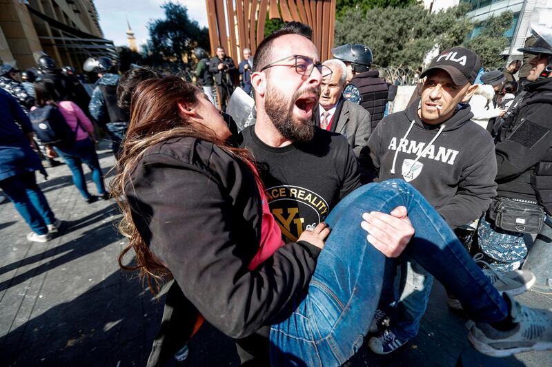 An anti-government protester carries away an unconscious woman during a demonstration in the centre of the Lebanese capital Beirut.  AFP