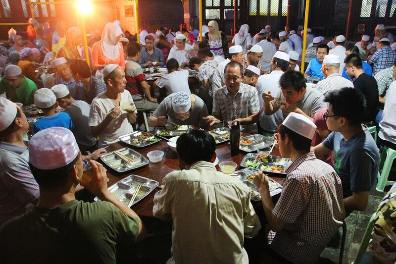 Niujie Mosque's predominantly Hui congregation enjoy an iftar meal of steamed rice, buns, lamb soup, fried aubergine and bak choi. Xiao Yi for The National