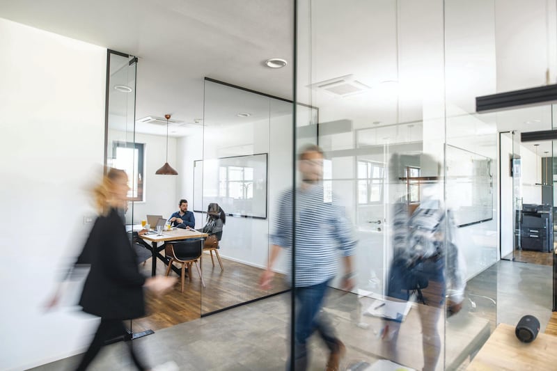 Blurred motion of energetic businesspeople on the go and project team members discussing ideas in a conference room.