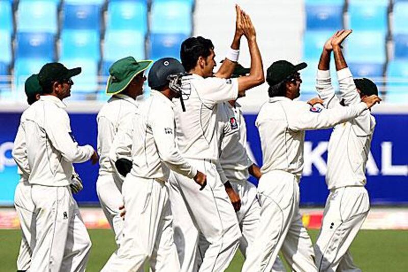 Pakistan celebrate Umar Gul, centre, taking the wicket of the Sri Lankan opener Lahiru Thirimanne on a productive morning on the first day of the second Test for Pakistan in Dubai