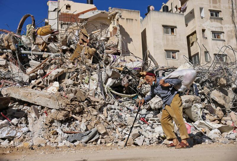 An elderly Palestinian man walks past a building destroyed by Israel's bombardment in Gaza City. AFP