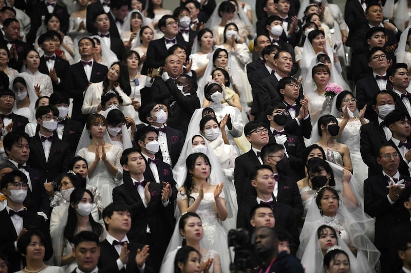 Couples wearing protective face masks attend a mass wedding ceremony organised by the Unification Church at Cheongshim Peace World Center in Gapyeong.  AFP