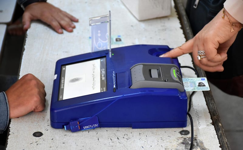 An Iraqi voter has her biometric voting card checked with her fingerprint upon arriving at a poll station in the northern multi-ethnic city of Kirkuk on May 12, 2018, as the country votes in the first parliamentary election since declaring victory over the Islamic State (IS) group. Polling stations opened at 7:00 am for the roughly 24.5 million registered voters to cast their ballots across the conflict-scarred nation. / AFP / Marwan IBRAHIM
