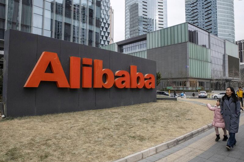 People walk past the Alibaba Group Holdings Ltd. signage displayed outside the company's Beijing office in Beijing, China, on Wednesday, Jan. 30, 2019. Alibaba is scheduled to release its third-quarter earnings figures on Jan. 30. Photographer: Gilles Sabrie/Bloomberg