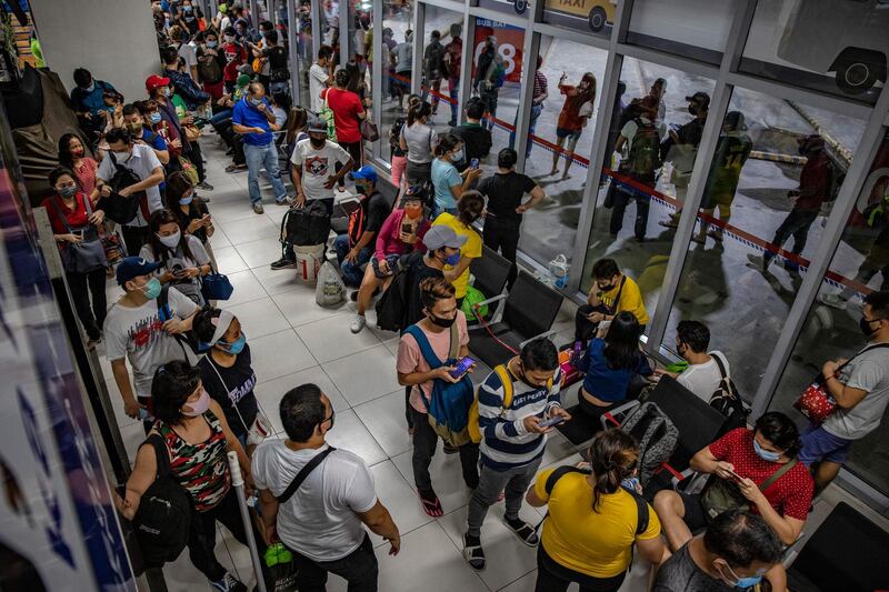 Commuters queue at a bus station a day before the government reimposes a strict lockdown in Parañaque, Metro Manila. Getty Images