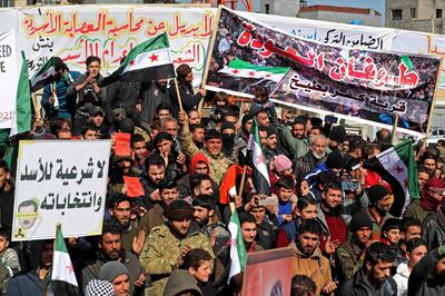 Displaced Syrians demonstrate against President Bashar al-Assad and the upcoming presidential election in the rebel-held city of Idlib on February 19, 2021. / AFP / OMAR HAJ KADOUR
