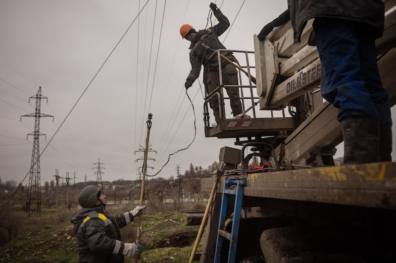 Electricity workers fix a destroyed high voltage power line in December in Kherson, Ukraine. Getty