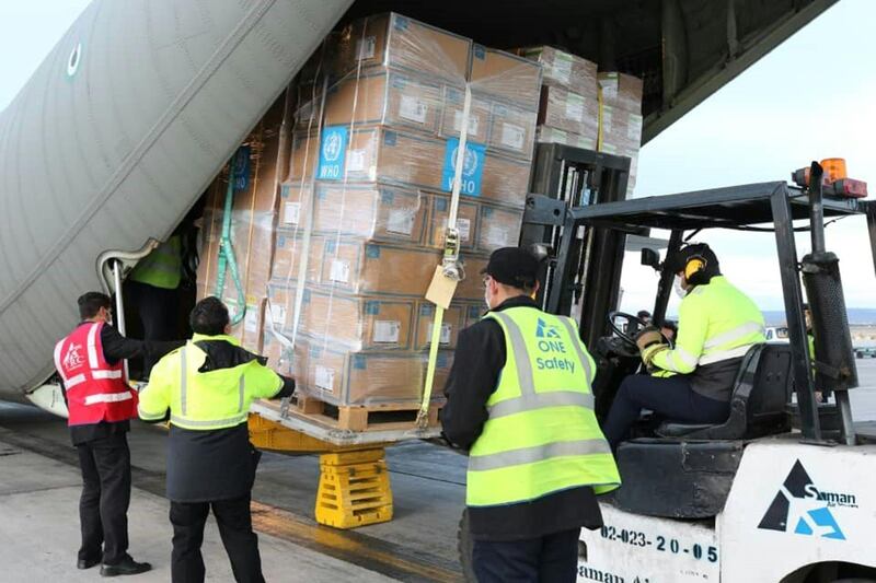Labourers unloading medical equipment and coronavirus testing kits provided by the World Health Organisation, from a UAE military transport plane upon their arrival in Iran. AFP