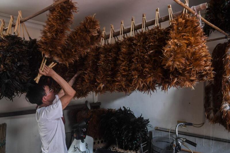 Nguyen Huy Luan hangs newly made chicken-feather dusters to dry at his house on the outskirts of Hanoi. Hoang Dinh Nam / AFP / June 6, 2017