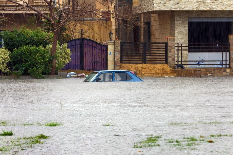 This picture taken on March 12, 2020 shows a view of an inundated car in a flooded street in  in the New Cairo suburb of the Egyptian capital amidst a heavy rain storm.  / AFP / -
