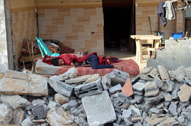 A Palestinian boy sleeps in the ruins of his family house in Gaza City that was destroyed in Israeli air strikes during the most recent Israeli-Palestinian fighting.