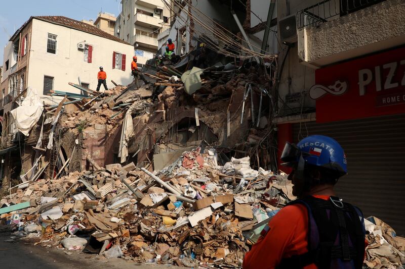 Rescue workers dig through the rubble of a badly damaged building in  Lebanon's capital Beirut in search of possible survivors from a mega-blast at the adjacent port one month ago. Reuters