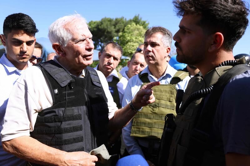 EU foreign policy chief Josep Borrell speaks to a soldier as Israeli Foreign Minister Eli Cohen listens on at Kibbutz Be'eri near the Gazan border on November 16. AFP