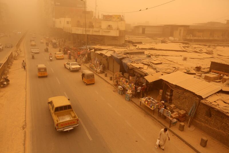Cars drive along a street at the Shorja market shrouded in heavy dust in Baghdad. EPA