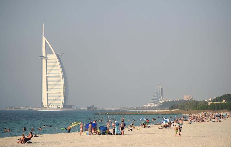 DUBAI, UNITED ARAB EMIRATES - SEPTEMBER 11: Locals and expats join holiday makers as they relax on the beach with Burj Al Arab in the background ahead of  Eid Al-Adha on September 11, 2016 in Dubai, United Arab Emirates. Muslims across the world are preparing to celebrate Eid Al-Adha, or the Festival of Sacrifice, which marks the end of the Hajj pilgrimage to Mecca which thousands of Muslims all over the world embark on.  (Photo by Tom Dulat/Getty Images)