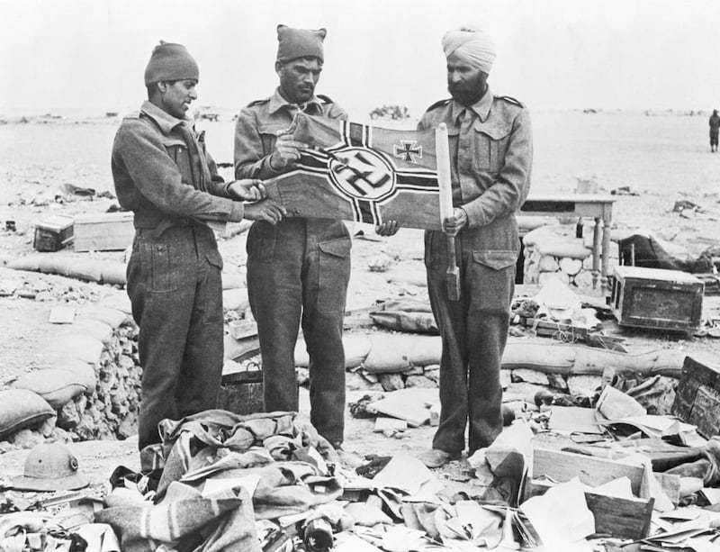 Indian troops with a Nazi flag in the rubble of Western Desert trenches, Libya, in May 1942 after the capture of Omar Al Mukhtar, the resistance leader against the Italian occupation. Up to 2.5 million Indians fought for Britain during the Second World War. Bettmann / Corbis / Getty Images.