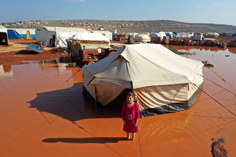 A girl standing outside a tent at the flooded Mukhayyam Al Khair camp near the village of Kafr Uruq in the north of Idlib province. AFP
