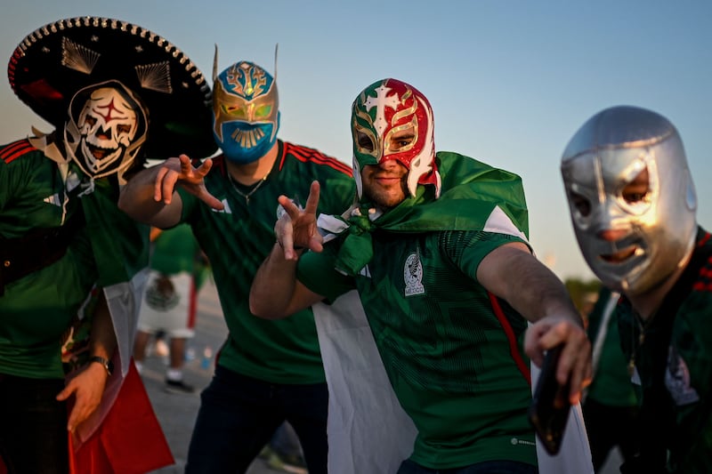 Masked Mexican supporters arrive for the World Cup match against Poland at Stadium 974. AFP