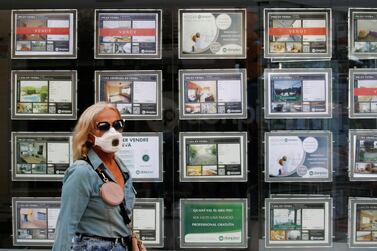 A woman walks past a real estate agency office in El Masnou, north of Barcelona, Spain, last month. House-price declines are felt sharply in a country where home ownership approaches 80%. Photo: Reuters