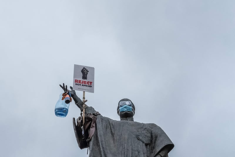The statue of the late Kenyan minister of justice Tom Mboya is adorned with a placard reading 'Reject not Amend' ahead of a planned demonstration against a now-withdrawn tax bill in Nairobi. AFP