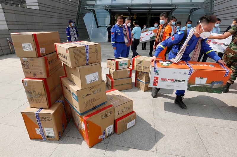 A Chinese official carries medical supplies to a truck after a handover ceremony at the Council of Ministers in Phnom Penh, Cambodia. China donated medical supplies to Cambodia to prevent the spread of coronavirus. EPA